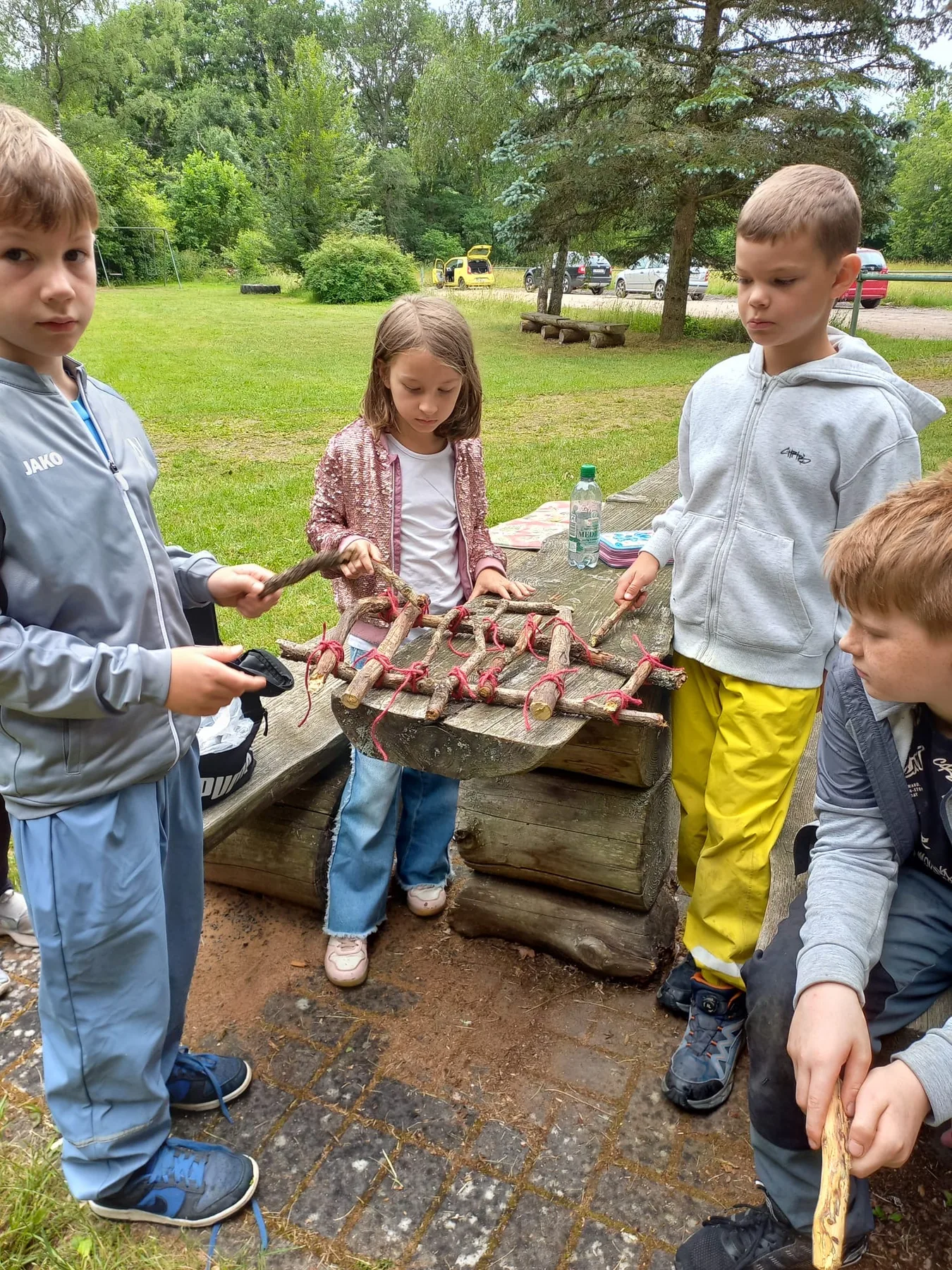 Kinder gestalten draußen mit Naturmaterialien.